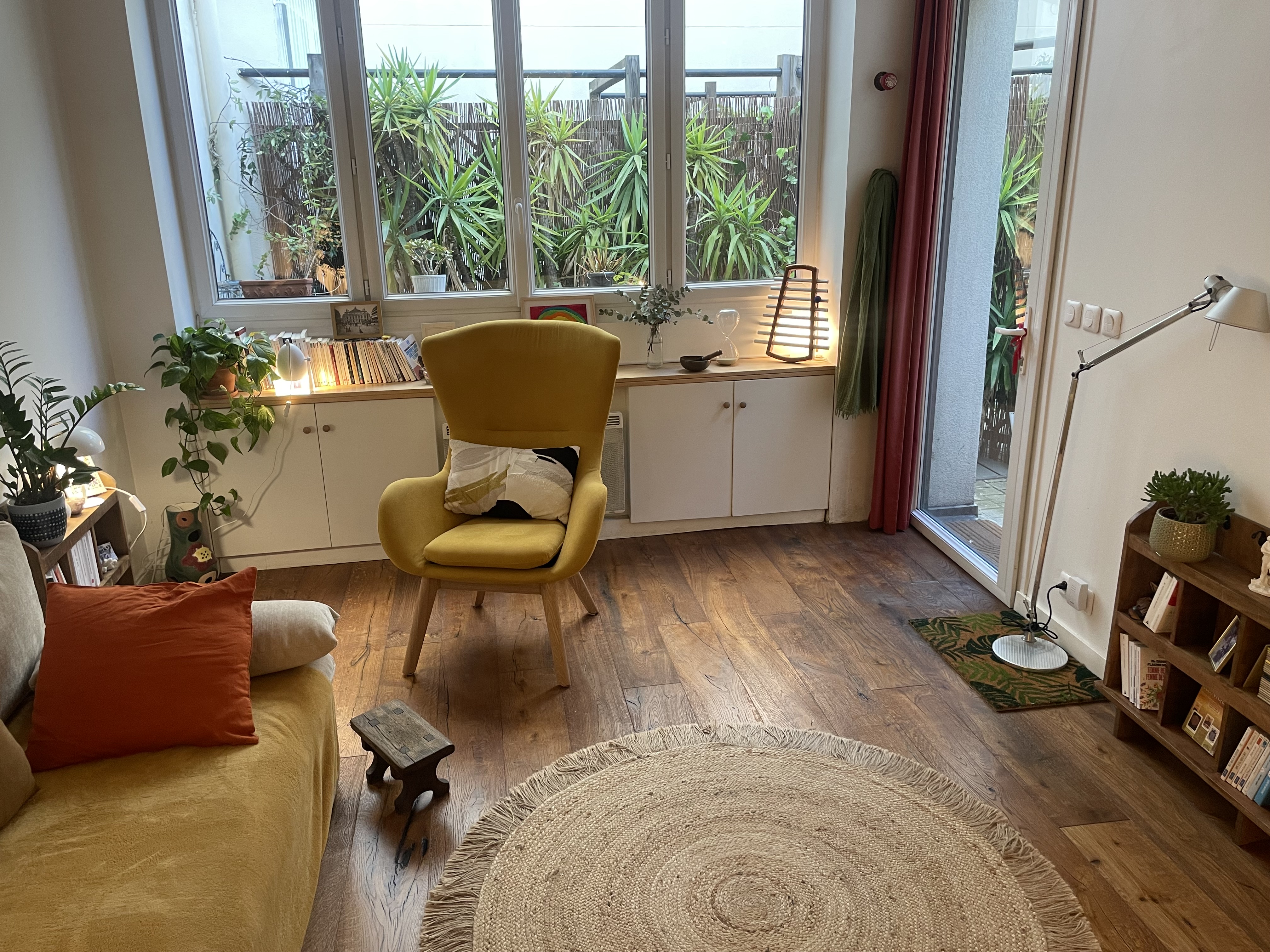 Vue d'ensemble du cabinet — fauteuils jaunes, tapis rond, canapé
